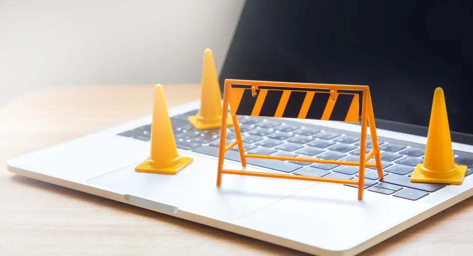 Traffic cones and barrier on a laptop keyboard.